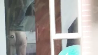 Следит через окно за голой фигуристой телкой, принимающей душ